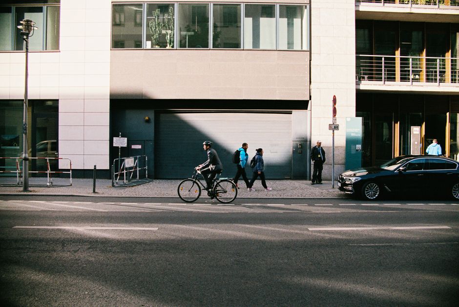 Cyclist on a historic cobblestone street in Boston, with the main city traffic blurred in the background, symbolizing a un...