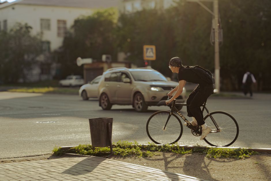 A focused shot of a cyclist on a quiet side street, with the larger, generic urban city scape softly out of focus, highlighting the choice to make competition irrelevant.